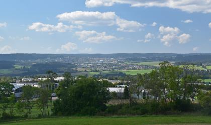 Blick von der Königskanzel nach Westen in den Nordschwarzwald bei Freudenstadt Blick von einem Aussichtspunkt auf eine hügelige Landschaft mit Waldinseln, nahen und fernen Siedlungen sowie langgezogenen bewaldeten Bergen im Hintergrund.