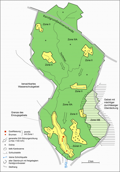 Beispiel für ein Wasserschutzgebiet für vier Grundwasserfassungen in einem Karstgrundwasserleiter (Villinger, 1991) Blick auf eine mehrfarbige, vereinfacht ausgeführte Karte für ein beispielhaftes Wasserschutzgebiet mit Quellfassungen und Brunnen in einem Karstgrundwasserleiter.