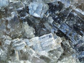 Nahaufnahme von splittrigem, milchigem bis durchsichtigem Gestein unterschiedlicher Größe und Farbe.