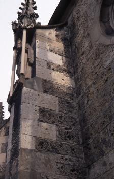 Stiftskirche St. Amandus in Bad Urach, Strebepfeiler auf der Südseite Teilansicht einer Kirchenwand mit linksseitig angebautem Strebepfeiler aus dunkelgrauen Mauersteinen. Teilweise sind auch hellgraue Steine verbaut.