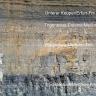 Teilansicht einer hohen, unterschiedlich gefärbten Steinbruchwand. Die einzelnen, auch in der Beschaffenheit unterschiedlichen, horizontal verlaufenden Sedimente sind beschriftet.