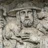 Detailaufnahme eines aus grünlich grauem Gestein gefertigten Reliefs. Das Relief stellt einen Schäfer mit Hirtenstab dar, der ein Schaf auf der Schulter trägt.