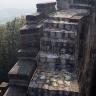 Blick auf eine treppenartig aufgebaute, hohe Burgmauer mit innenliegendem Treppenaufgang aus neueren Pflastersteinen.